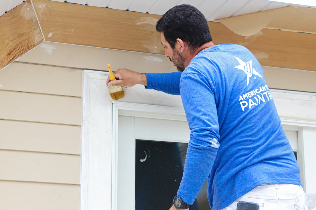 Crew brushing trim around an entry door