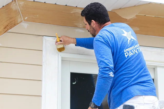 An American Town Painting painter brushing door trim